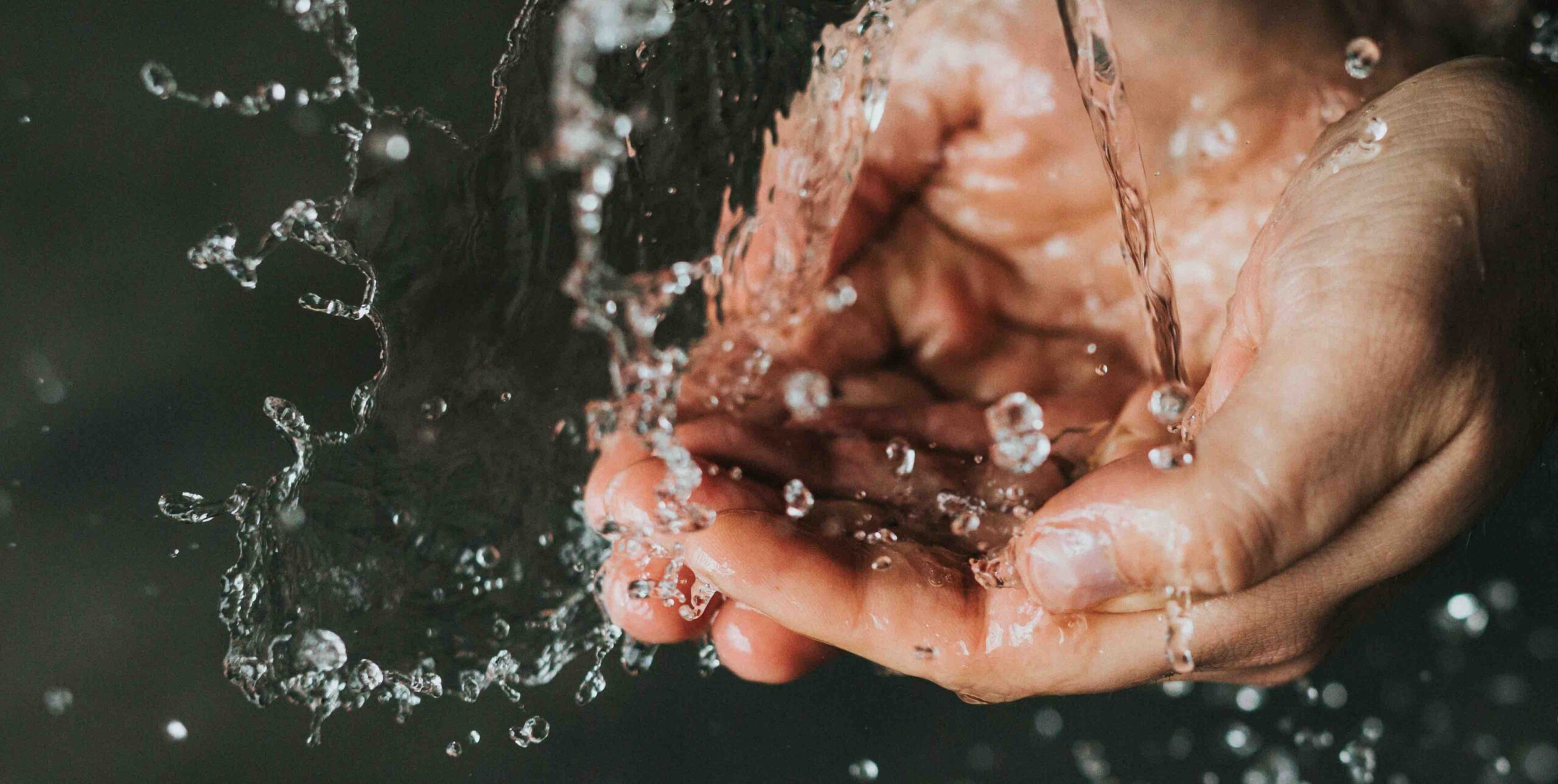 Wasserstrahl fällt auf Hände