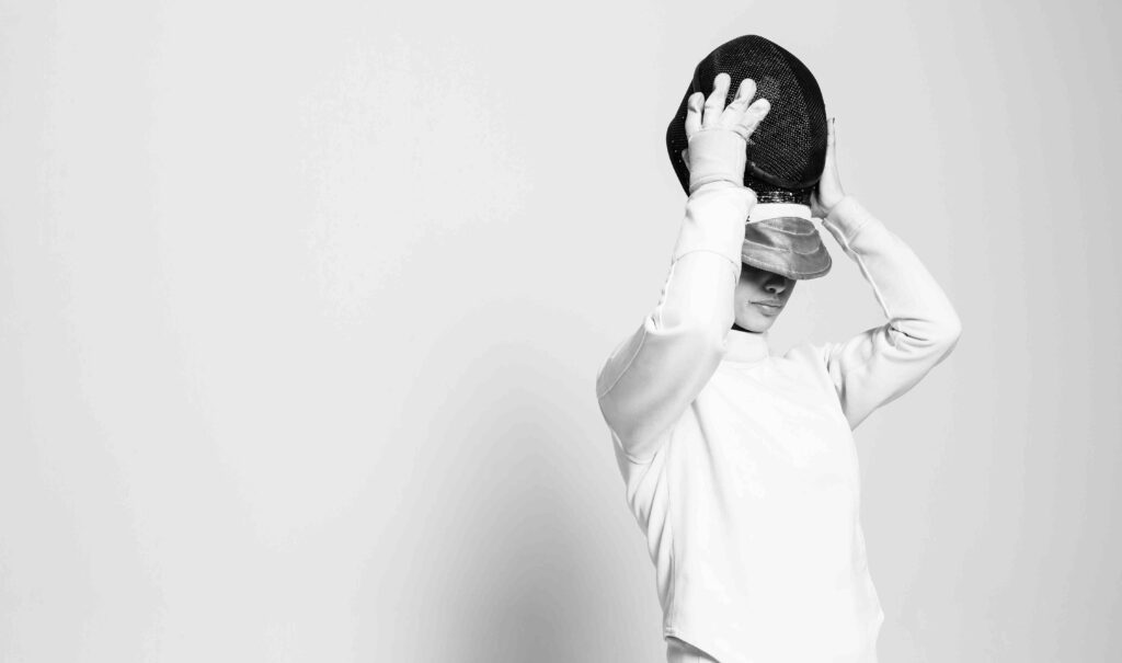 Fechterin zieht sich Helm über den Kopf